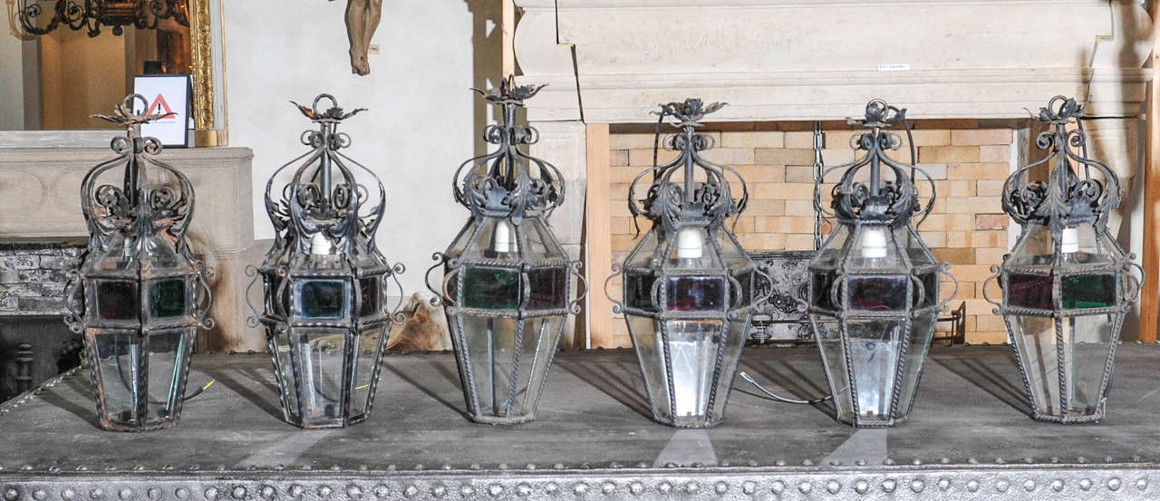 A near set of six French early 20th century cast iron and colored glass electrified lanterns, of which the sizes vary between 60-65 cm. Height and 28-32 cm. Diameter, also available per pair.