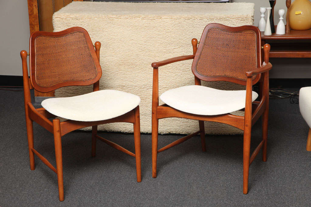 SOLD  Gorgeous Arne Vodder designed dining chairs in teak with inset caning on the movement adjusting backs, floating ergonomic seats newly upholstered in a white chocolate chenille.  One armed captain's chair and five armless sides.  Classic Danish