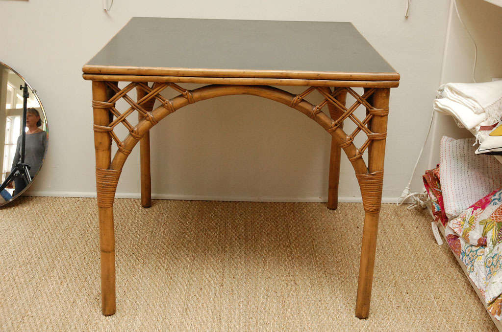 Vintage rattan card table with arched lattice apron. Black inset laminate top.