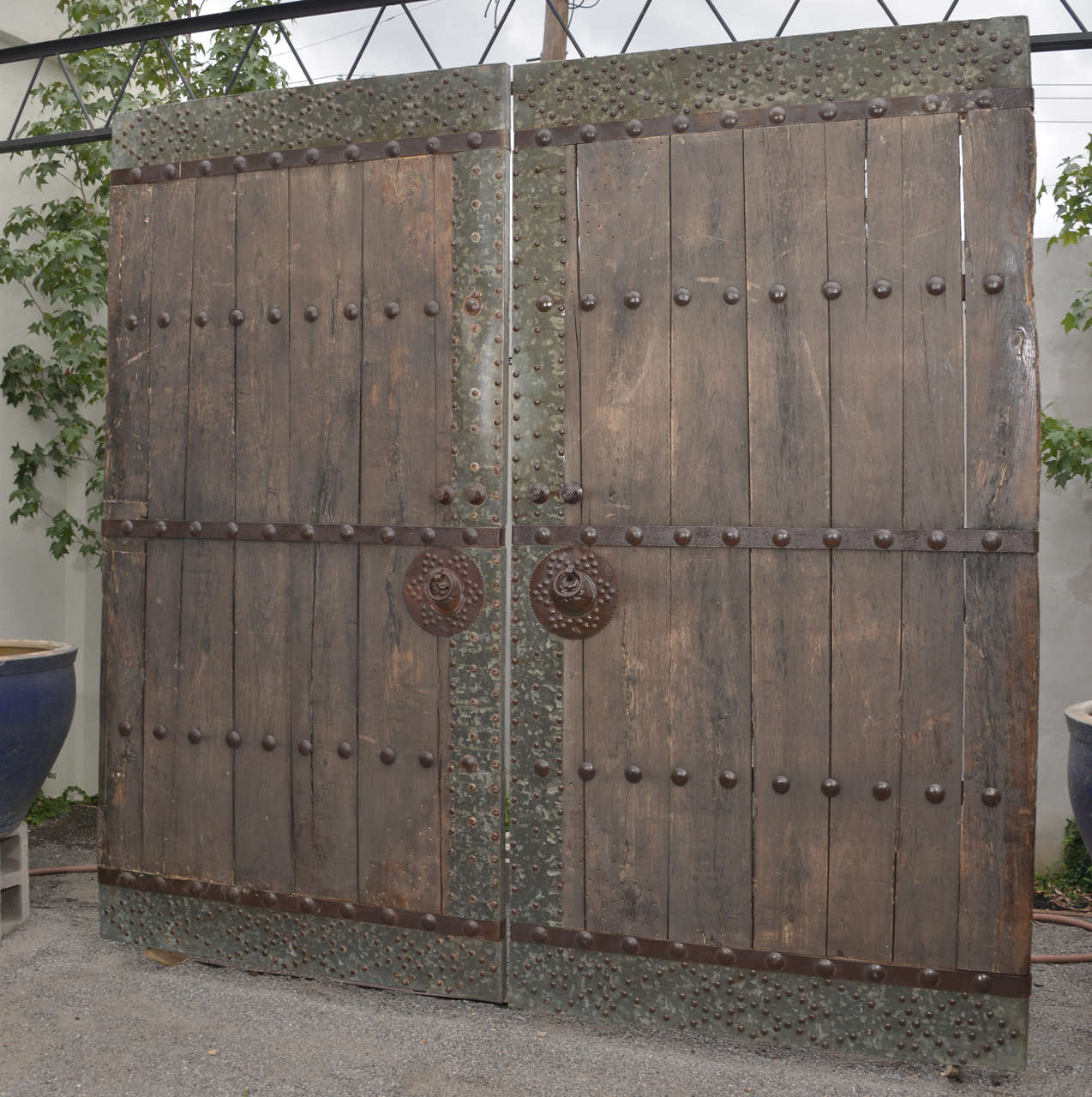 Weathered Elm Courtyard Doors
Pair of Antique Elm Doors with Studded Hardware Trim
 These doors came from a traditional Asian “quadrangle house.” 
Quadrangle houses are defined by their central courtyard. The courtyard was the 
entrance way for