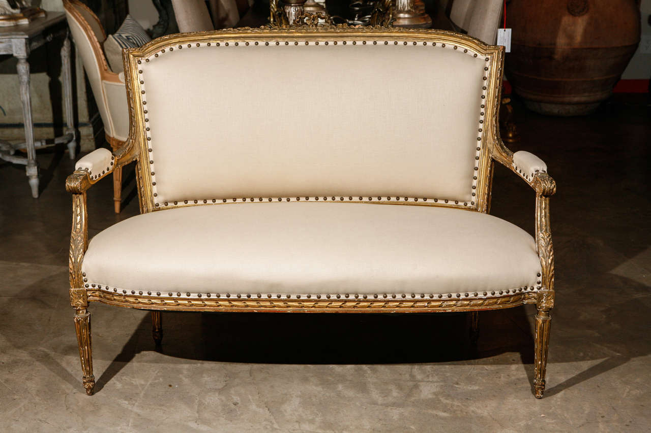 Reupholstered in linen with a gilt wood finish.