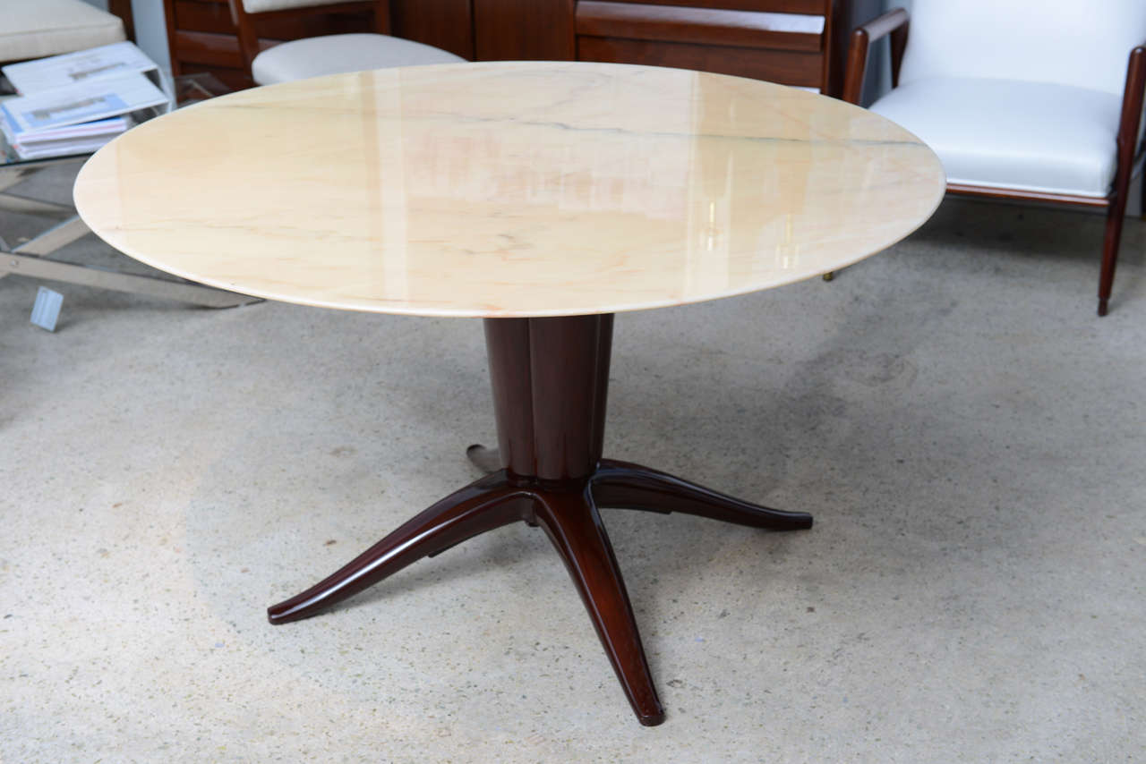 The onyx top above a mahogany base with quadripartite fluting and four splayed legs.