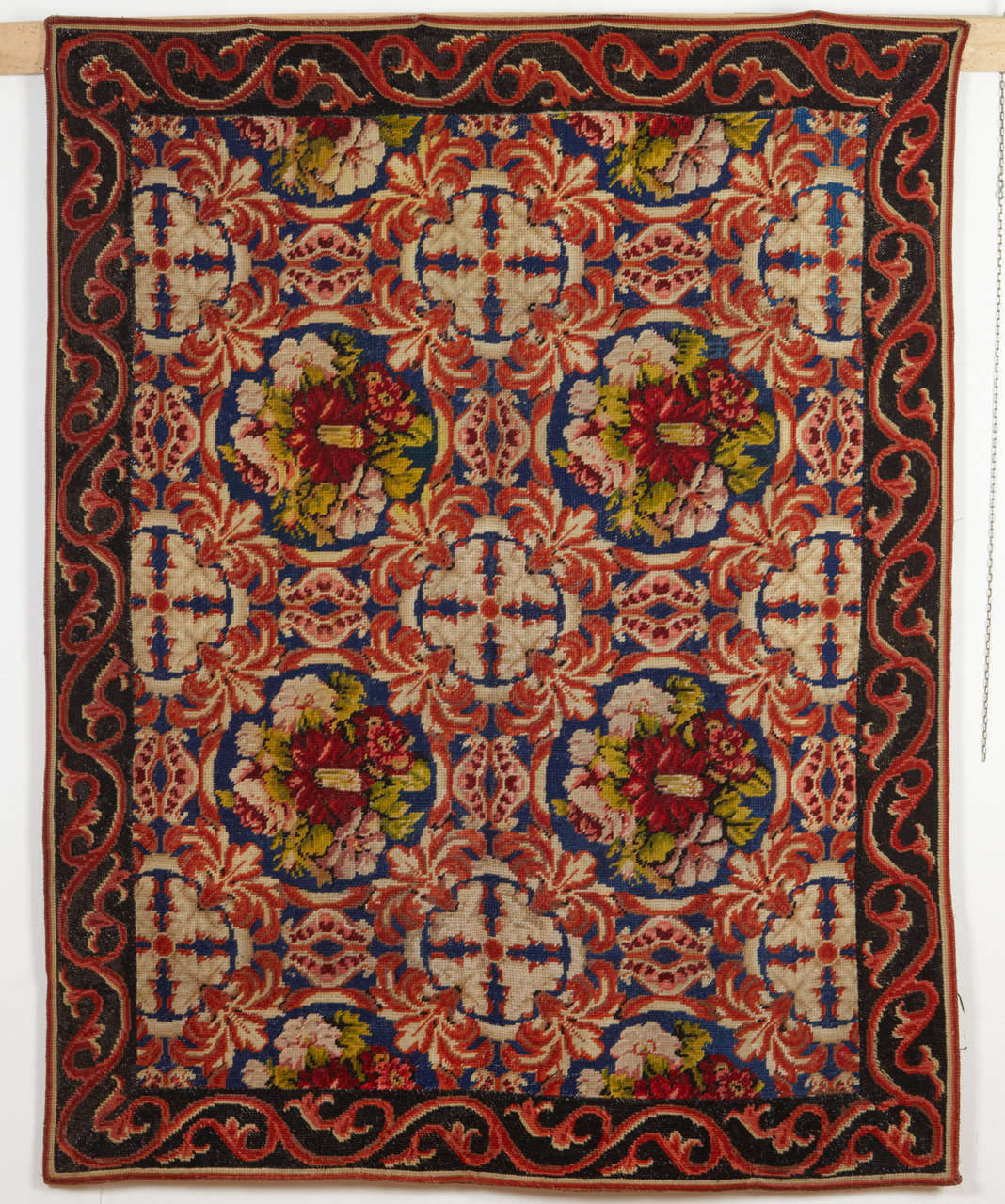 A charming needlepoint rug distinguished by an infinite repeat pattern of floral bouquets alternated by offset parallel rows of leafy roundels. English needlepoints such as this one represent the pinnacle of weaving in the Victorian era.


