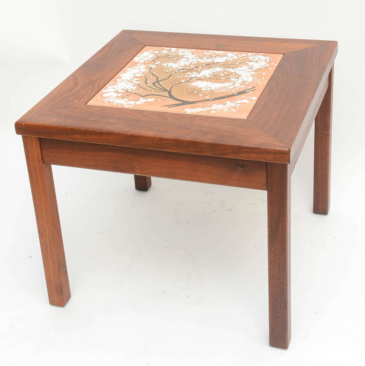 This handsome side table was created by Brown Saltman in the 1960s.  The enamel inset panel is decorated with a stylized cheery blossom tree, in colors of white, apricot and black/brown which compliment the walnut wood frame beautifully.

Note: 