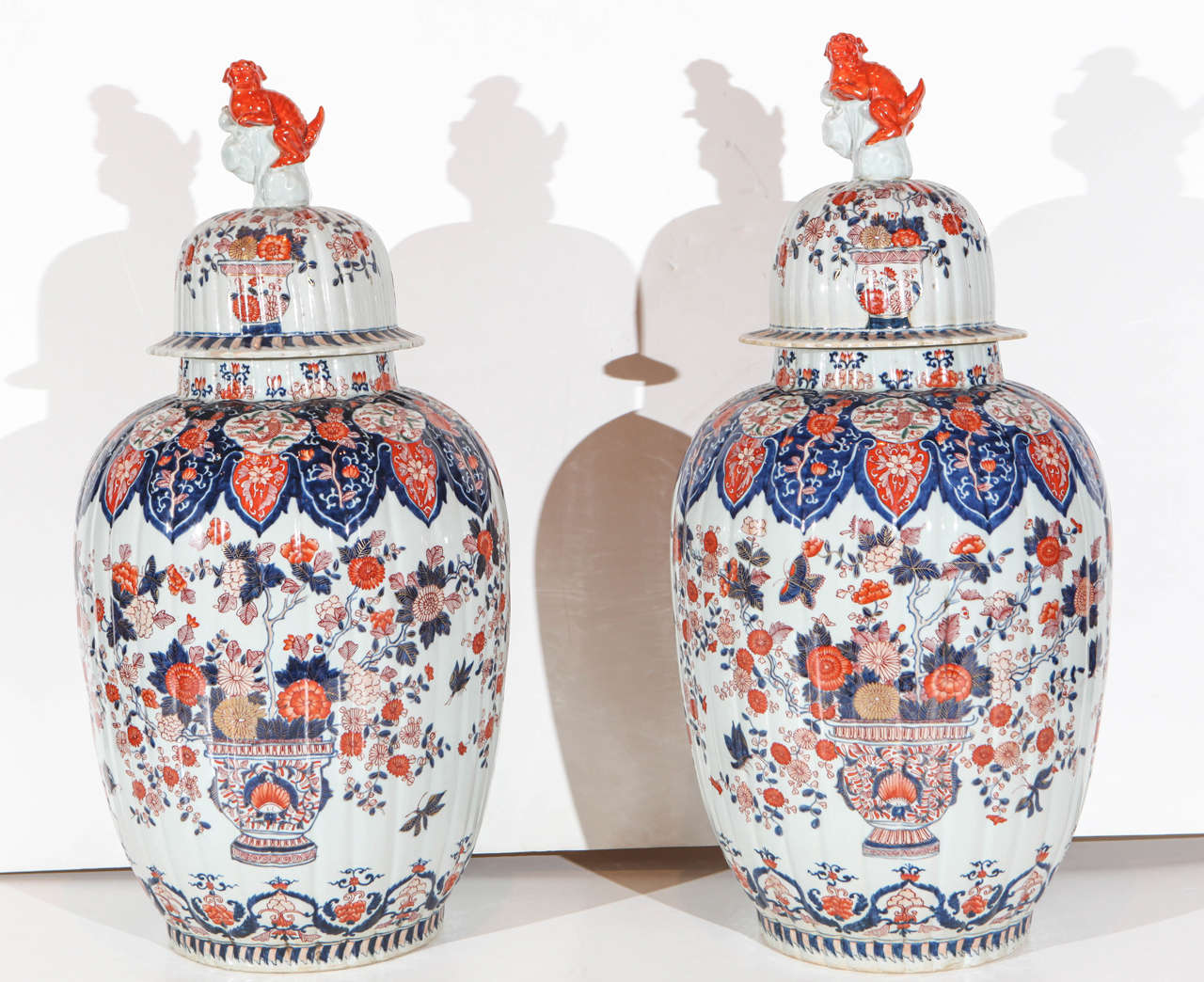 Pair of vibrant, early 20th century, hand painted and parcel gilt, lobed Imari jars with Foo dog embellished lids.