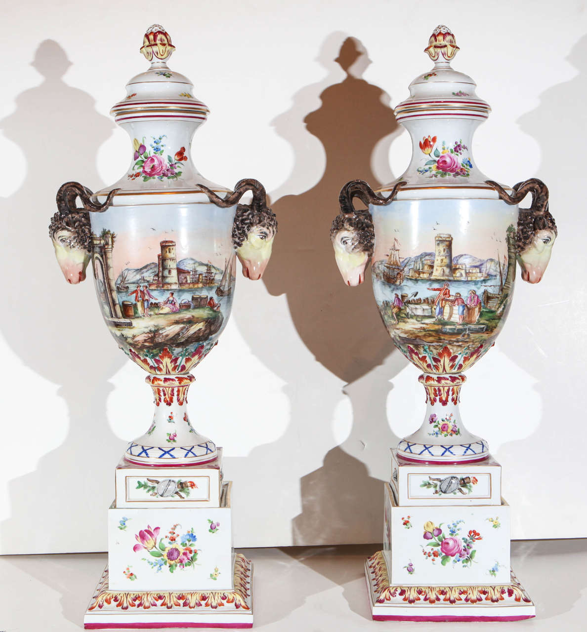 Pair of large, hand-painted, Italian urns with ram's head embellishments and Capriccio scenes.