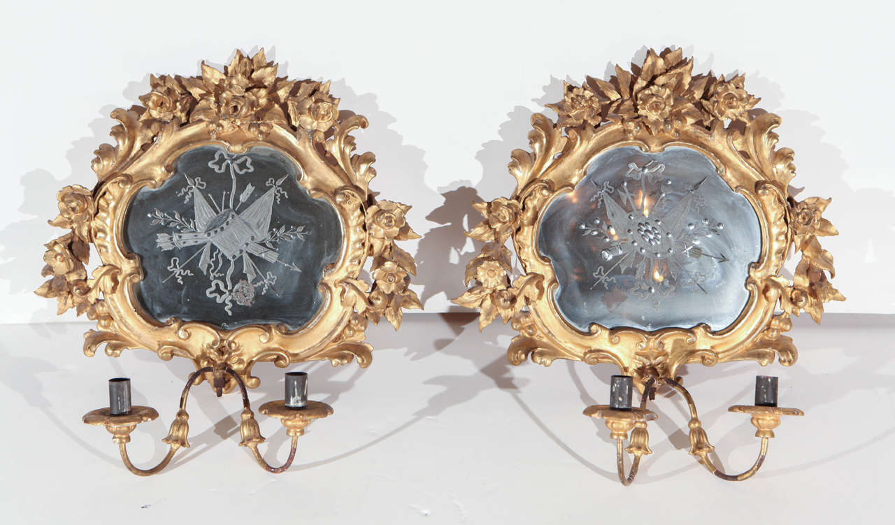 Pair of petite, hand-carved and gilded sconces with inset, etched mirrors featuring flags, drums and arrows.