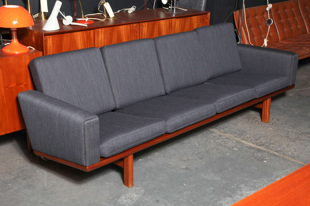 Vintage 1950s Hans Wegner Four-Seater Sofa by Getama

This Danish sofa is in like-new condition. We upholstered it in this striking grey fabric. The upholstered arms make it the perfect couch to lay down on and watch TV, read, or take a nap. The