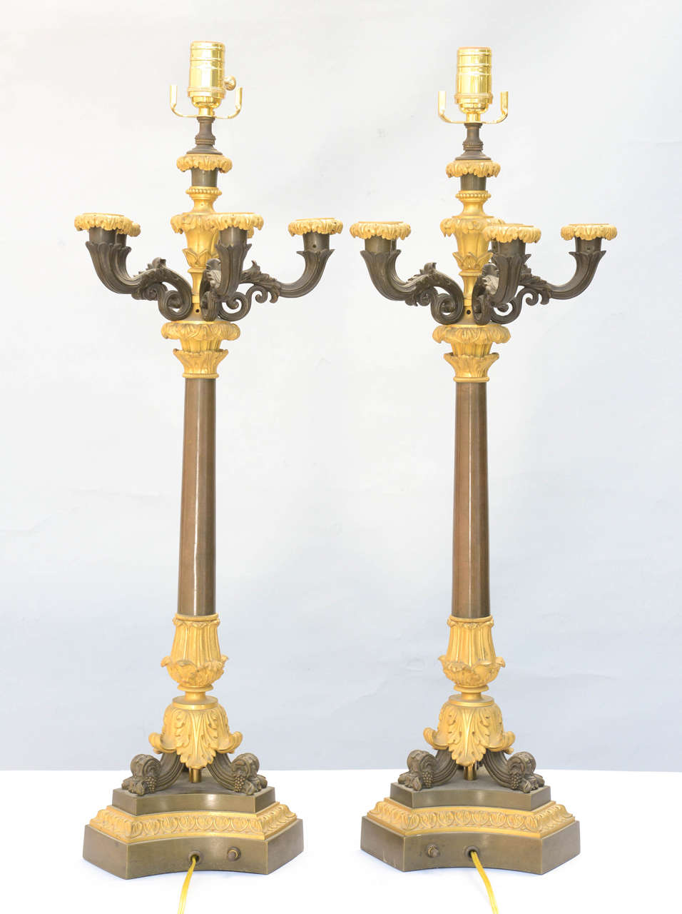 Pair of candlesticks, of patinated and dore bronze, each having five scrolling candlearms, raised on tripartite base; lamped.

Stock ID: D9163
