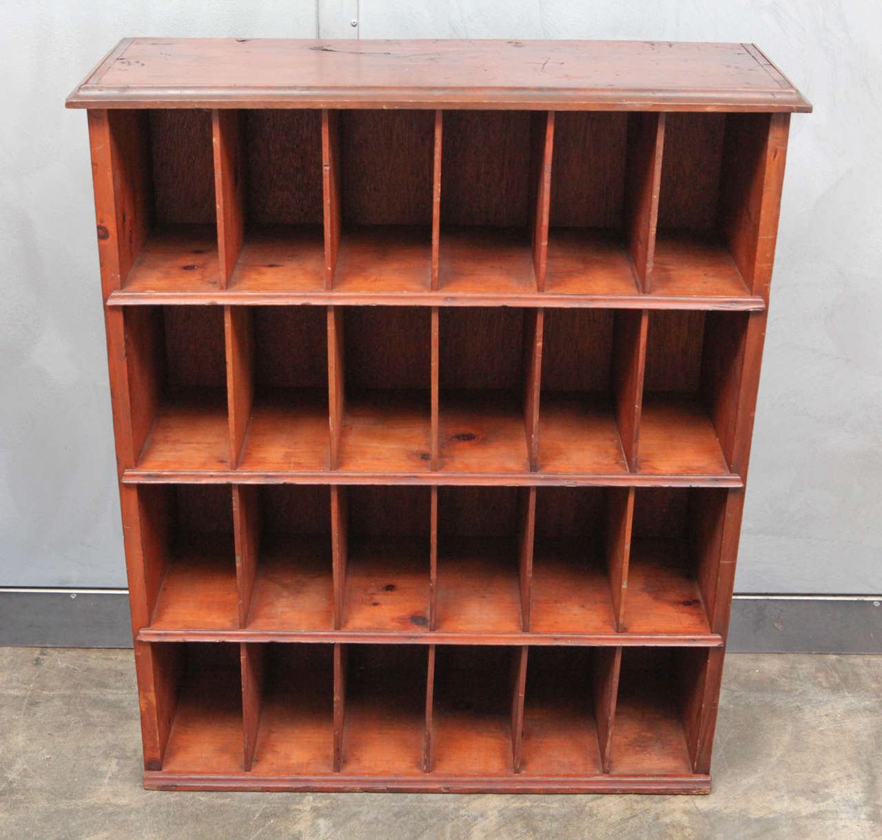 This great pine cabinet is well built and well worn with a wonderful finish in a rich golden color. The cabinets holds 24 separate cubbies that could have been used in a post office or a hotel lobby. This piece is ready for a variety of creative and