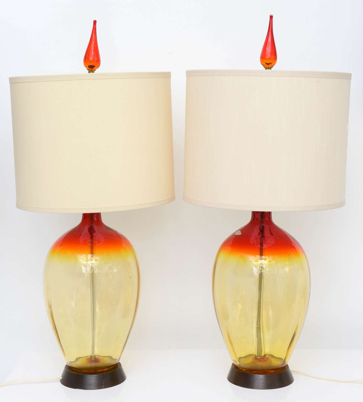 Pair of vintage blenko glass lamps with yellow to orange ombre. The lamps have three-way switches, original wiring, adjustable harps, shades and original teardrop glass finials.
