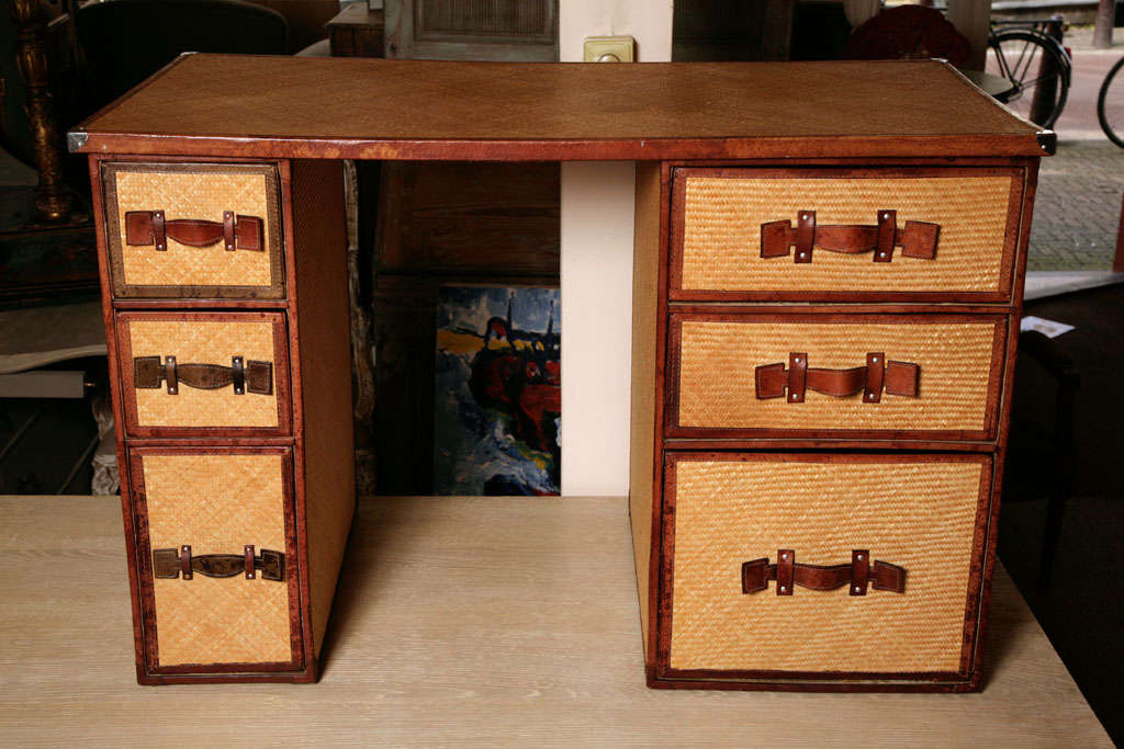 Desk consisting of 3 parts, 2 blocks with drawers and one top, all covered with fine woven cane.
The blocks gives the suggestion of suitcases.