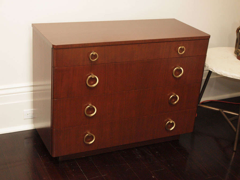 Handsome four-drawer chest in mahogany with round edged drawer fronts and attractive brass ring pulls; recessed base