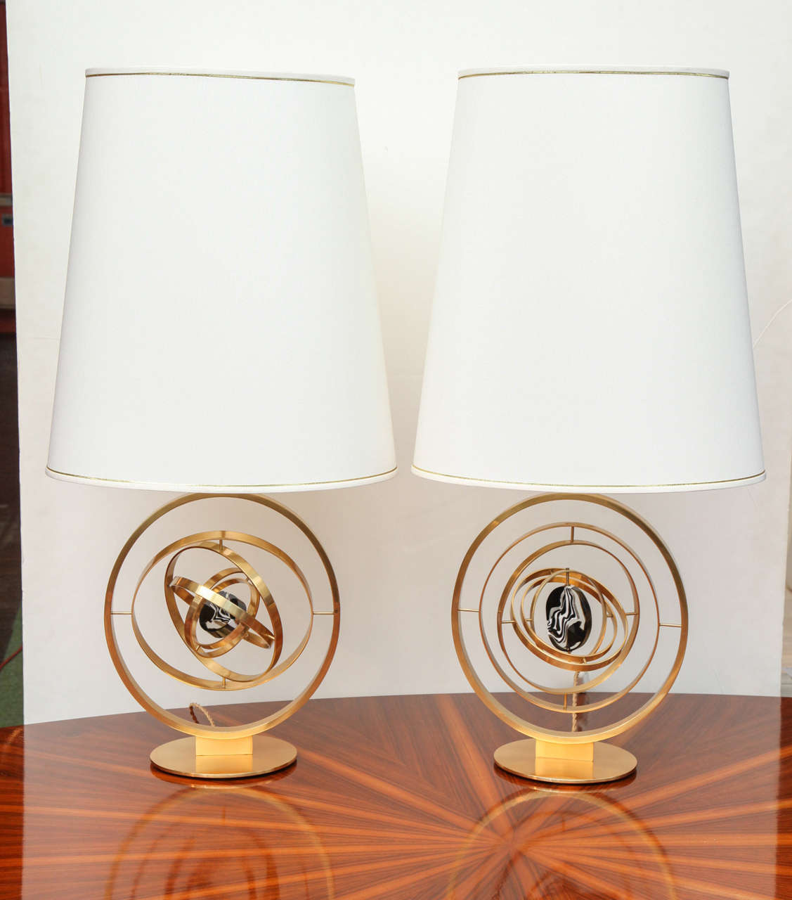 Studio built pair of "Giroscopio" lamps by Roberto Giulio Rida. Pivoting polished brass element's that recreate the movements of a gyroscope. Cast molten-glass centerpieces. Oval shaped fabric shades. These lamps are created around the