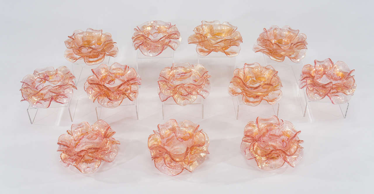 An unusual set of hand blown rose pink Venetian glass flower form dessert bowls. The bowls are made with applied petal layers, alternating in spiral pattern emulating a flower. A beautiful and decorative yet functional dessert bowl will embellish
