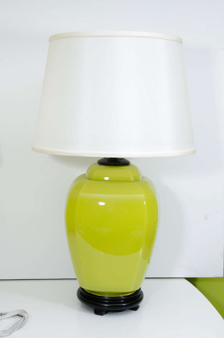 A pair of glass jar lamps in acid green on black wood base with linen shades. These are a nice size and perfect for adding a bright color to a neutral setting.