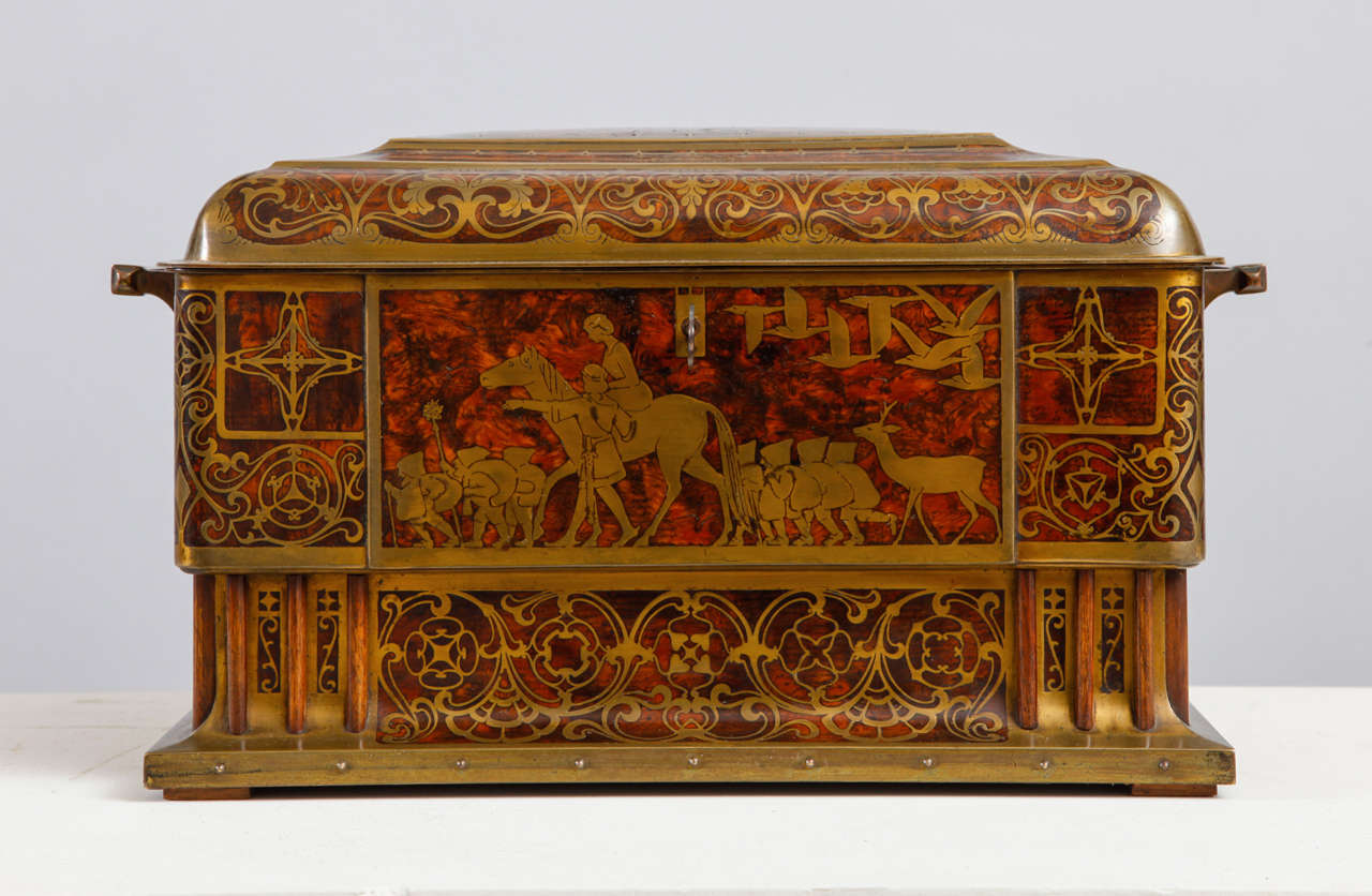 This refined table casket was made by Erhard & Söhne, a German family company in Schwäbisch Gmünd that was founded in 1844. The panels in Amboina wood are decorated with brass marquetry depicting figures and scenes of tales by the famous Danish