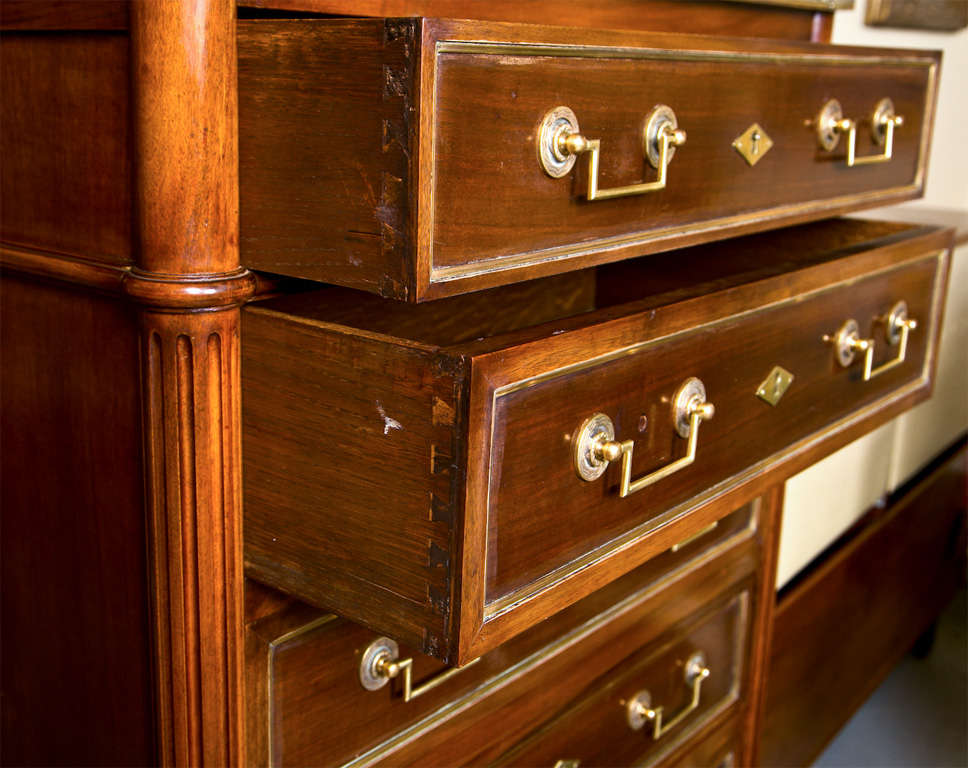 A handsome French Louis XVI style mahogany and bronze mounted semainier or lingerie chest, circa 1940s or earlier, the galleried top over a conforming case fitted with 6 drawers, each bronze banded, raised on tapering circular ending in capped feet.