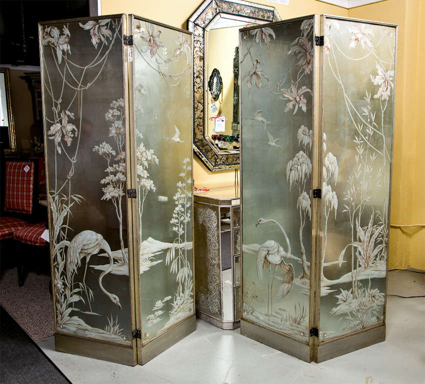 Glamorous Chinoiserie style etched & elogmise 4-panel screen in a silver-leaf frame, stunning vintage piece and truly one-of-a-kind. Depicting a beautiful scene of cranes playing on a pond with flowers and trees on the background. A spectacular