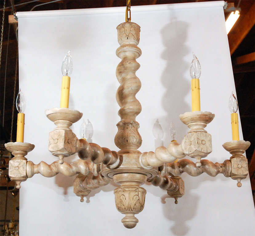 a decorative and interesting light fixture in limed oak. Each of the six lights are held at the end of a twisted arm emitting from the central column. 