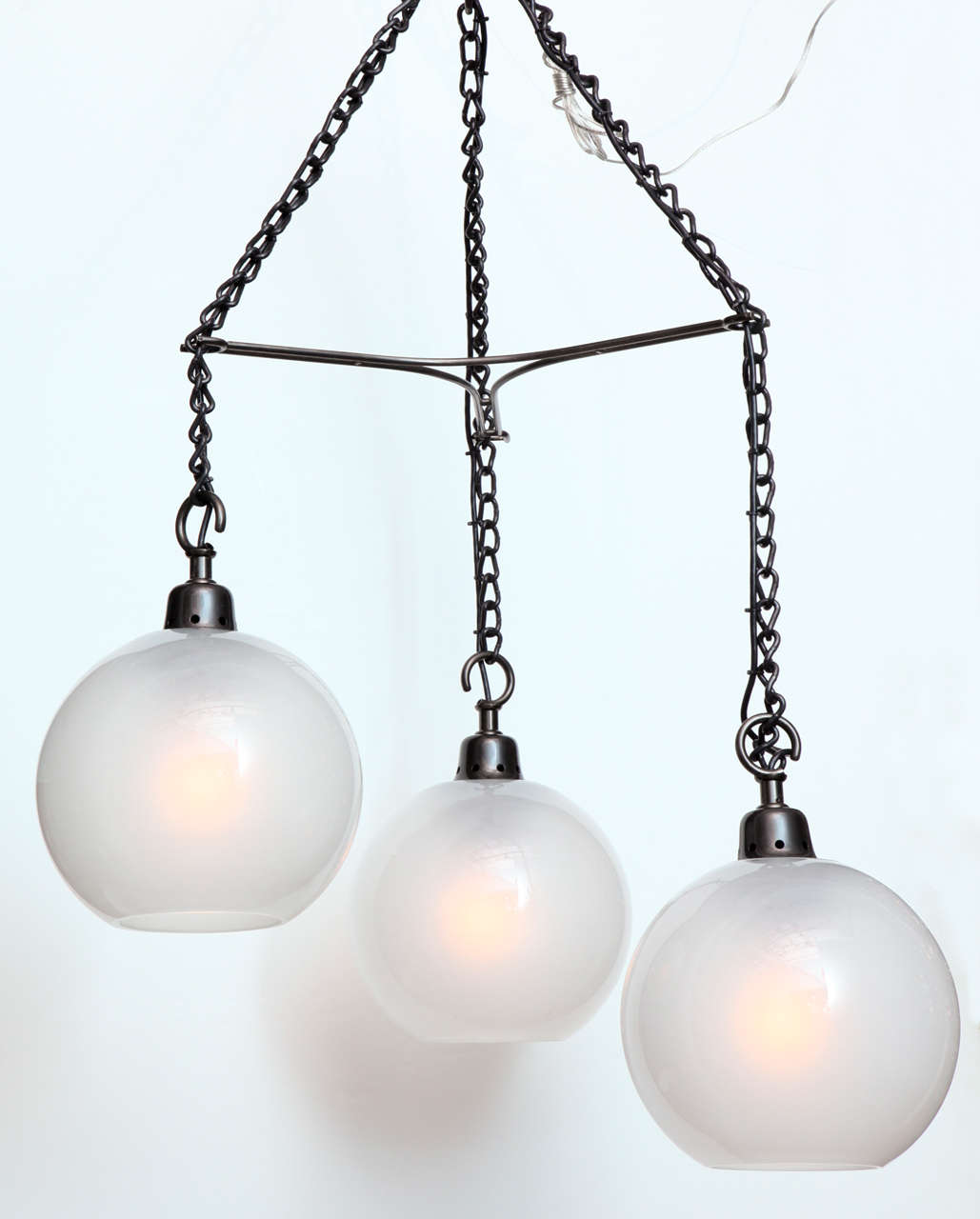 Three frosted Murano glass globes hanging from painted iron chains. Aluminum & iron mounts. Great scale & presence with an elegant industrial spirit.