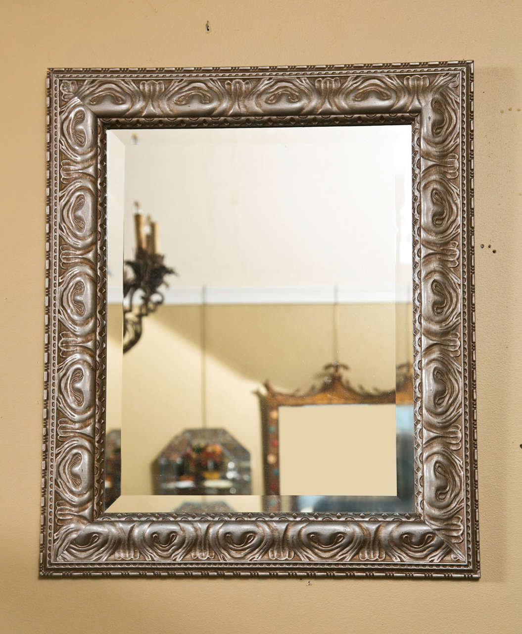 Paire de magnifiques miroirs dorés à l'argent, chacun ayant un verre rectangulaire biseauté surmonté d'un cadre en bois sculpté à la finition dorée à l'argent. Manière de Jansen.