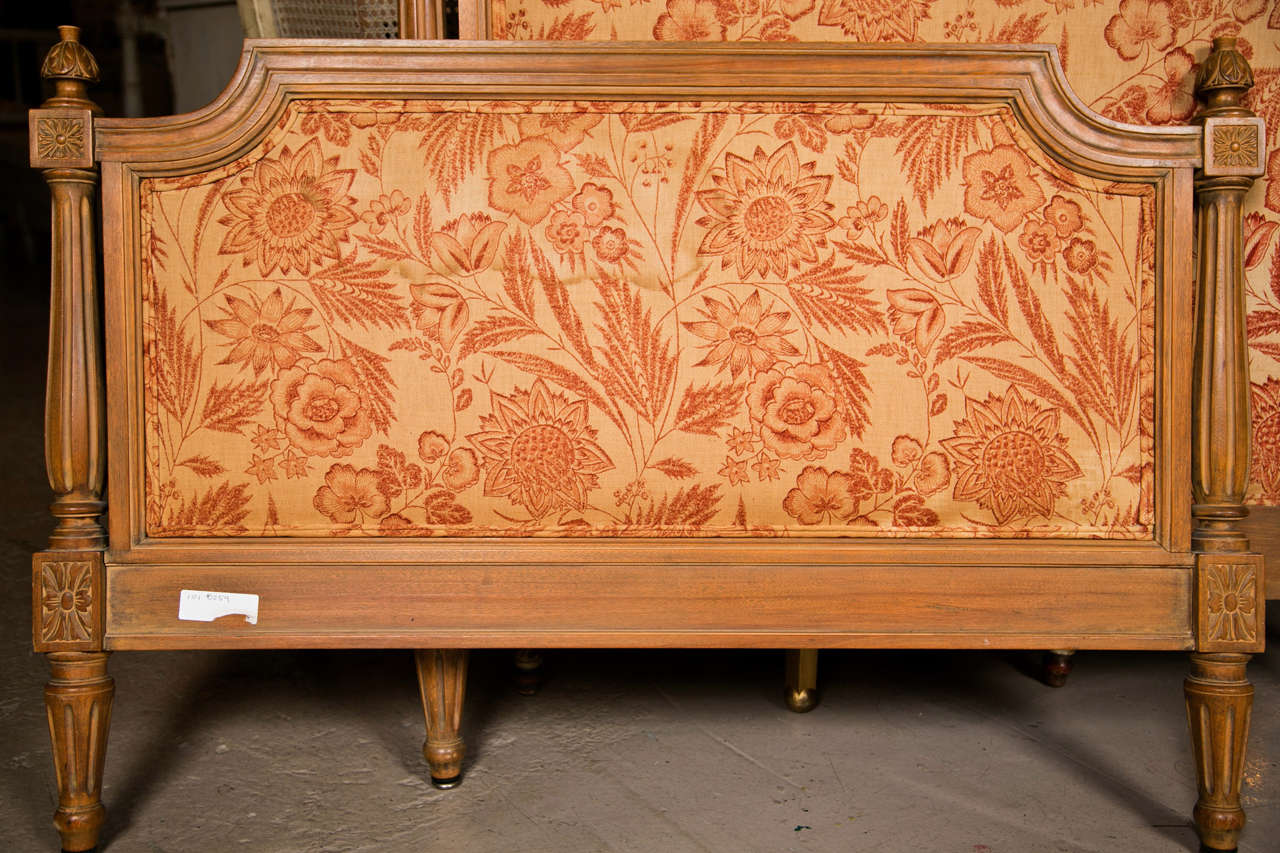 French Louis XVI style distressed twin size bed frame, headboard, foot board, and rails. Upholstered in red floral pattern fabric, raised on fluted tapering legs.  By Maison Jansen

Headboard Measurements: 
Height : 41.5 inches
Width:  42