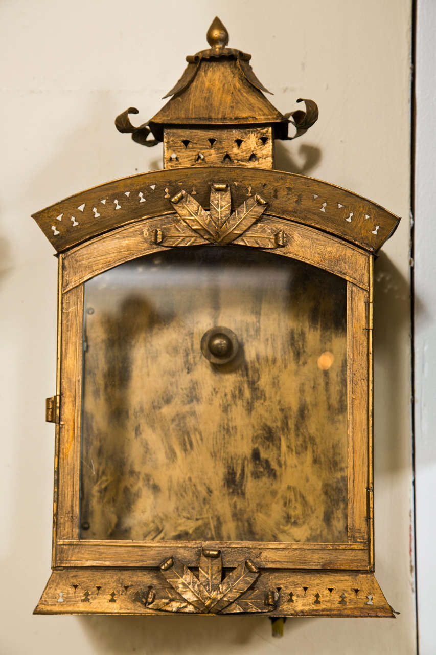 Pair of Tole Lantern Wall Sconces. Late 19th early 20th century. Each has a glass case opening to an enclosing shelf where the candlestick is placed. Both having pagoda tops. Original Paint finish.