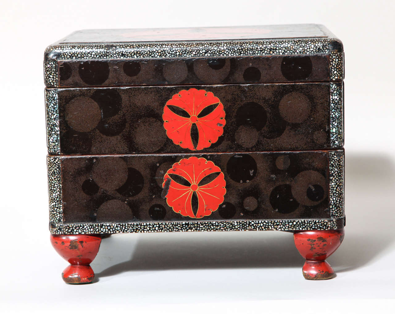 Antique Japanese lacquer tiered box comprised of two stacked trays and a cover, the whole supported on four squat cabriole legs. The top and sides have a black rectangular panel set on a placed aogai ground, each panel featuring subtle overlapping