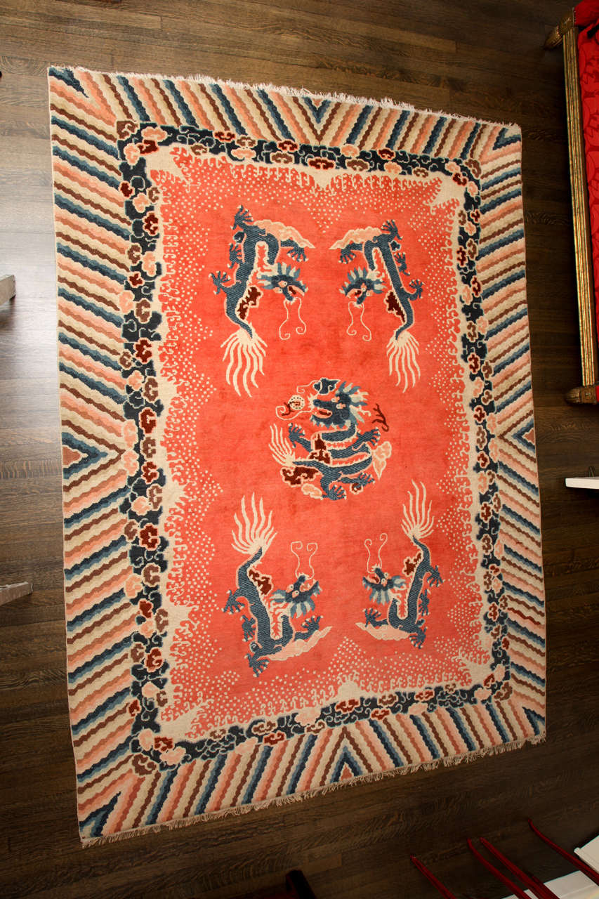 Antique Chinese dragon carpet having a melon field with central and four flanking five-clawed dragons in indigo and cream within a polychrome wave and cloud border. Pad included.

Size: 10’2” X 7’5”.