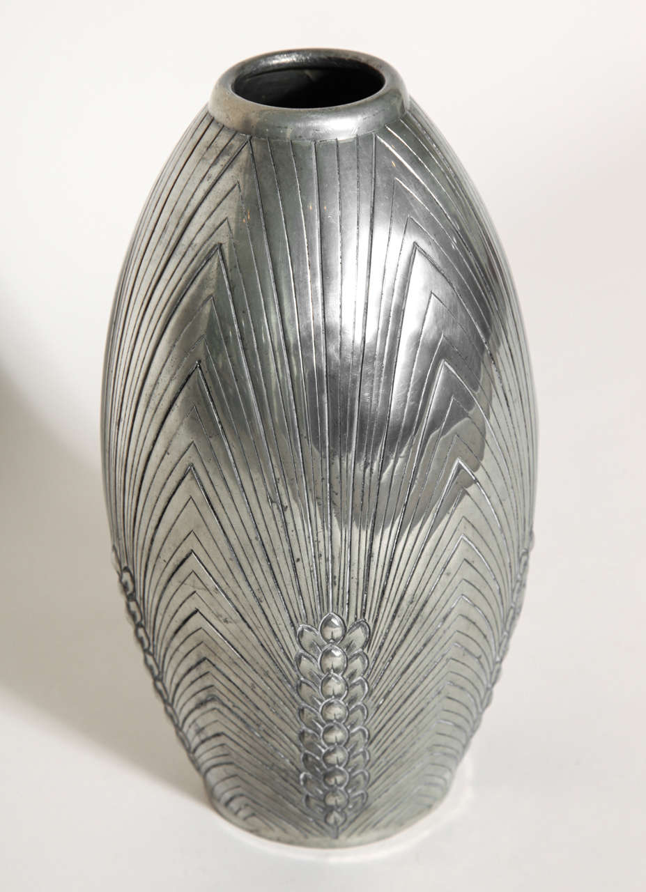 Handwrought ovoid dinanderie pewter vase with linear radiation from vertical branches around the base.
Signed:  