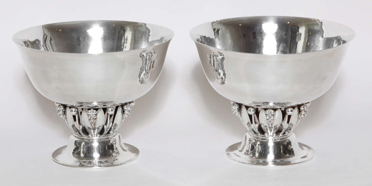 Each circular, with flaring rim on an openwork base with bunches of grapes and leaves, on a domed and spreading circular foot.
Hallmarks: Georg Jensen mark for 1919-1927/ 197 A/ 925 S/ Danish Assay Mark dated 1923/ Copenhagen Assay Master C. F.