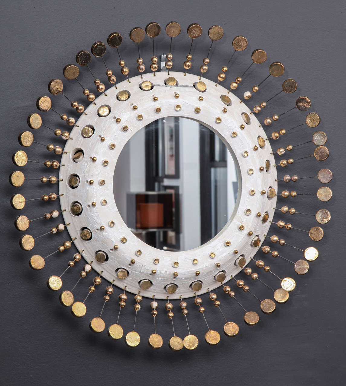Black glaze over ceramic embellished with gold paint, detailed with crackled glaze balls and disks on wire to form a stunning starburst mirror.
France 1940