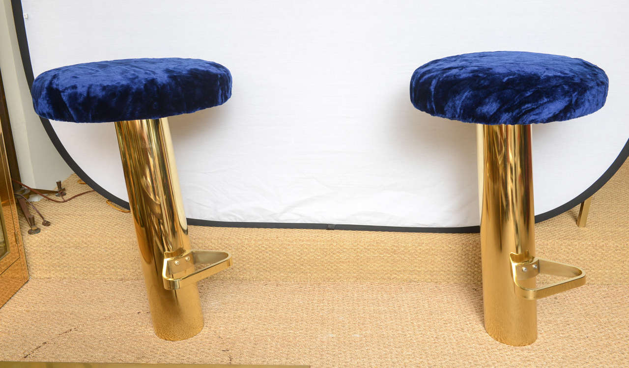 In the style of Karl Springer, these barstools came from a yacht. Beautifully polished, they are mounted to floor on a tilt through a metal base to floor that is hidden once installed. Note: these are meant to be affixed to floor - they are swivel
