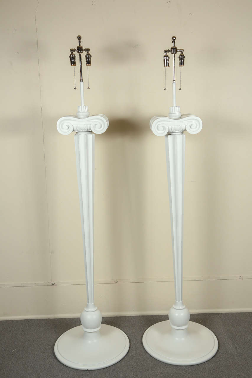 Spectacular and very unusual pair of Hollywood Regency floor lamps in the form of eccentric attenuated tapered ionic columns removed from the Eden Roc hotel.
They have a satin white finish and are newly rewired with nickel hardware and double