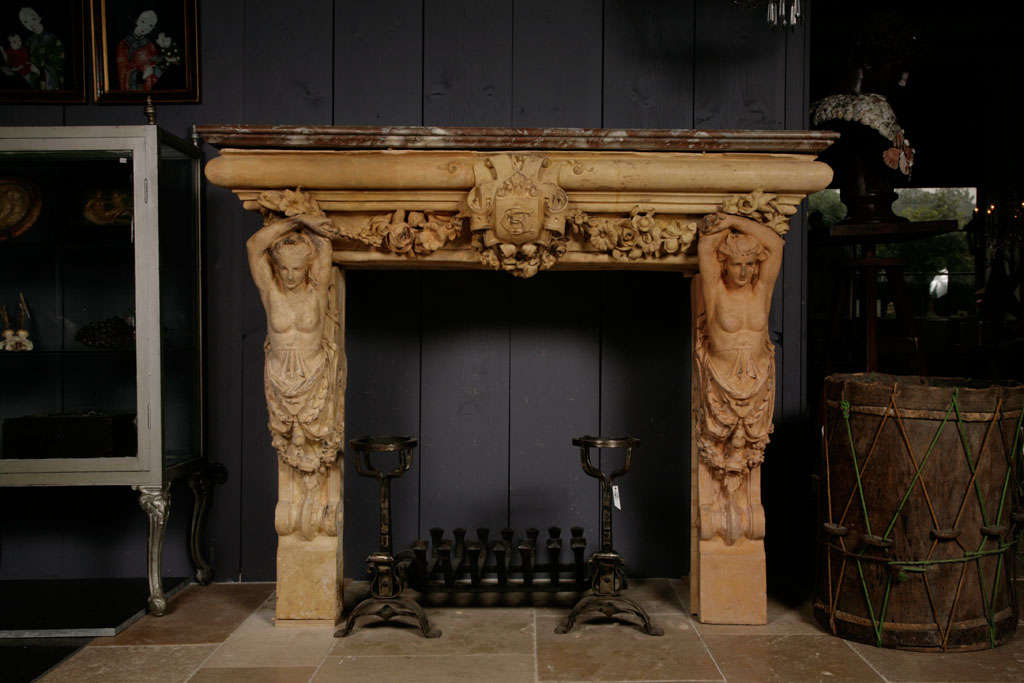A 19th Century French terracotta fireplace / mantel piece, flanked by two caryatids carrying a Rouge Royal marble top.