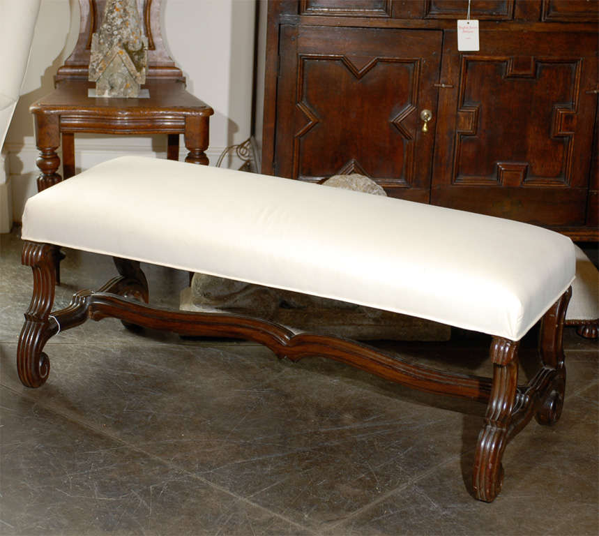 French bench with curved legs and stretcher in new muslin upholstery.
