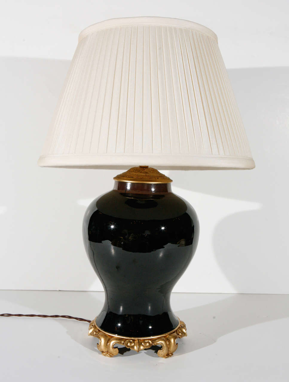 A robust, hand-painted and richly glazed table lamp atop a pierced, ormolu base. Surmounted by a custom, pleated, silk shade.

Height including shade: 27 inches
Diameter including shade: 18 inches