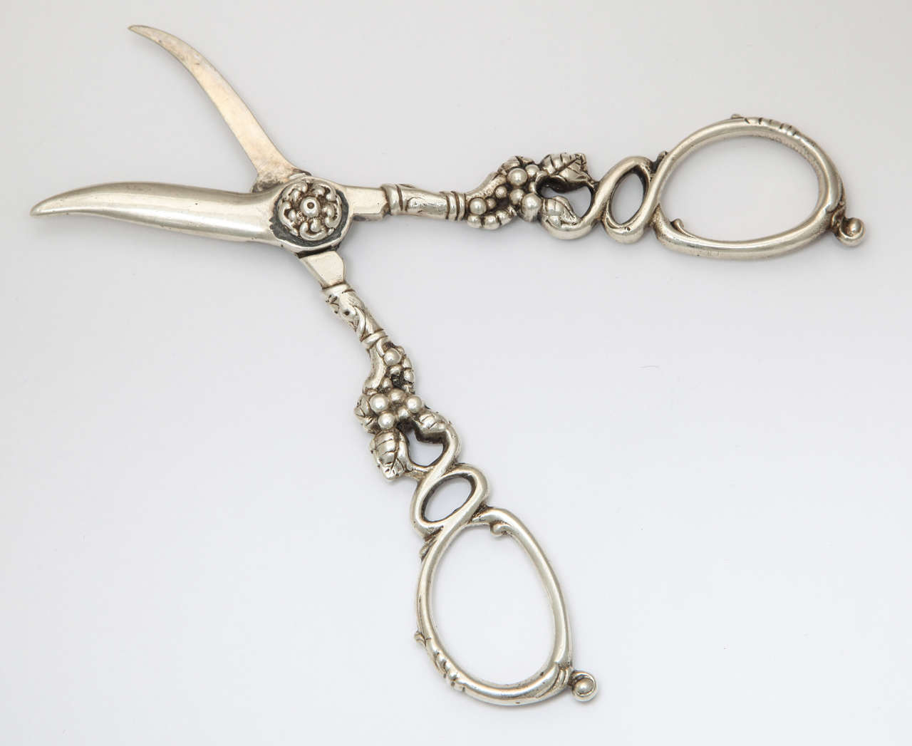This elobarate piece of sterling silver is decorated with vine design, which is appropriate, since they are grape shears. They are Victorian in age and are marked 