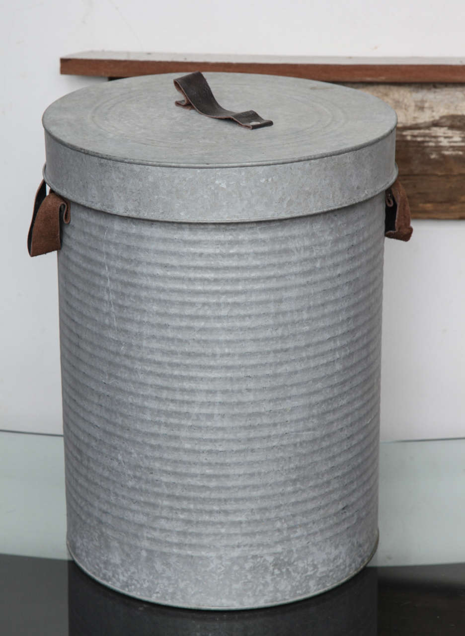 The galvanized container with lid and leather handles
 is a beautiful and unique antique.
It' has an  Industrial look.
The British cube is classical and chic. 
Exquisit in Equestrian decor.