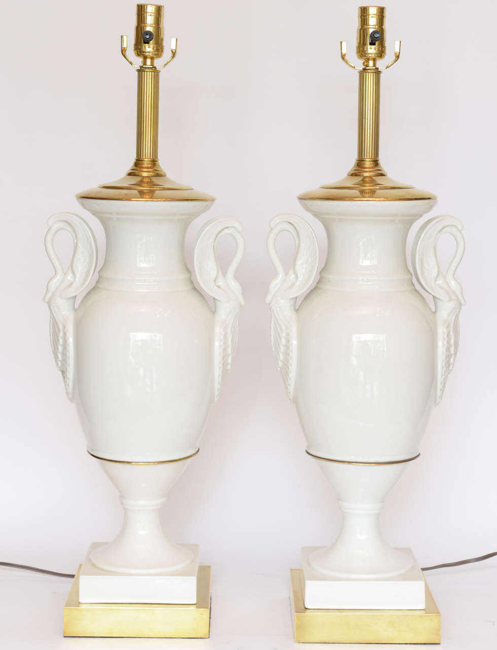Very fine pair of swan motif white porcelain lamps with brass trim.