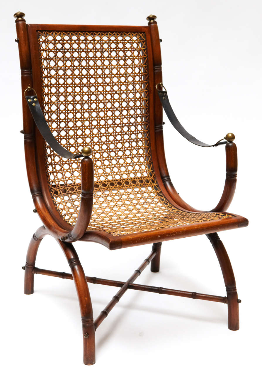 Early 20th century rare faux bamboo and cane fireside / club chairs, antique brass details and leather arm straps.