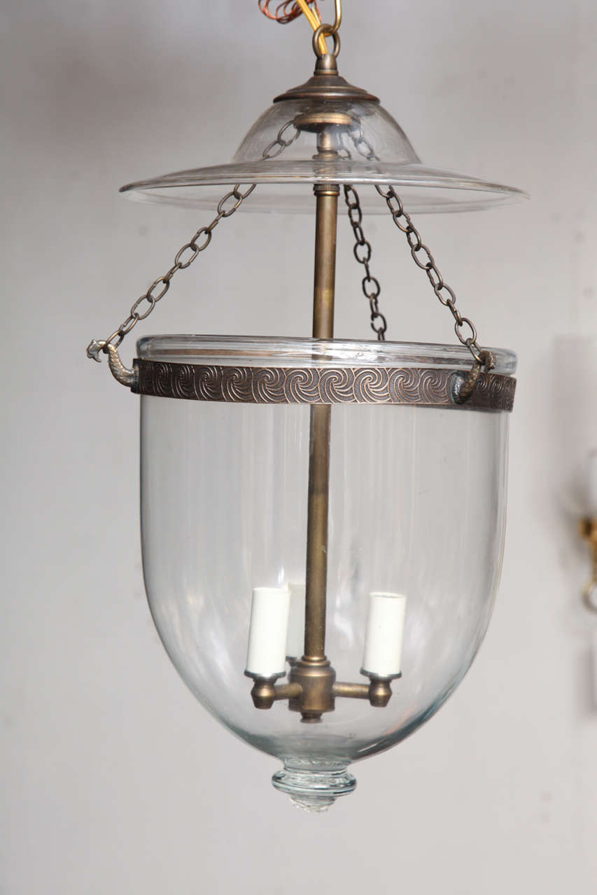antique handblown clear glass belljar with a brass band in antique finish.Price includes nonulwiring.