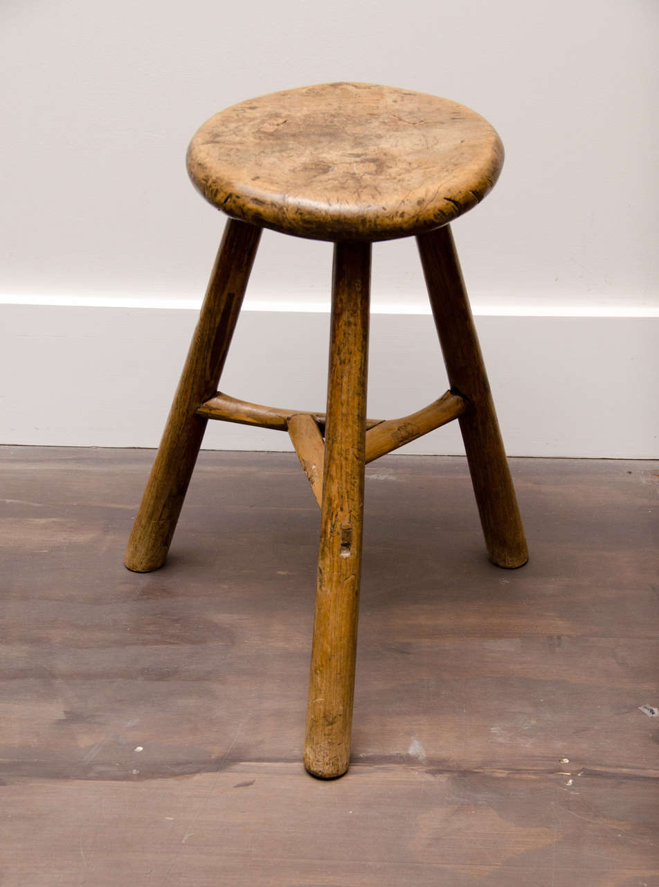 Antique wooden farm stool with three legs and very nice patina.