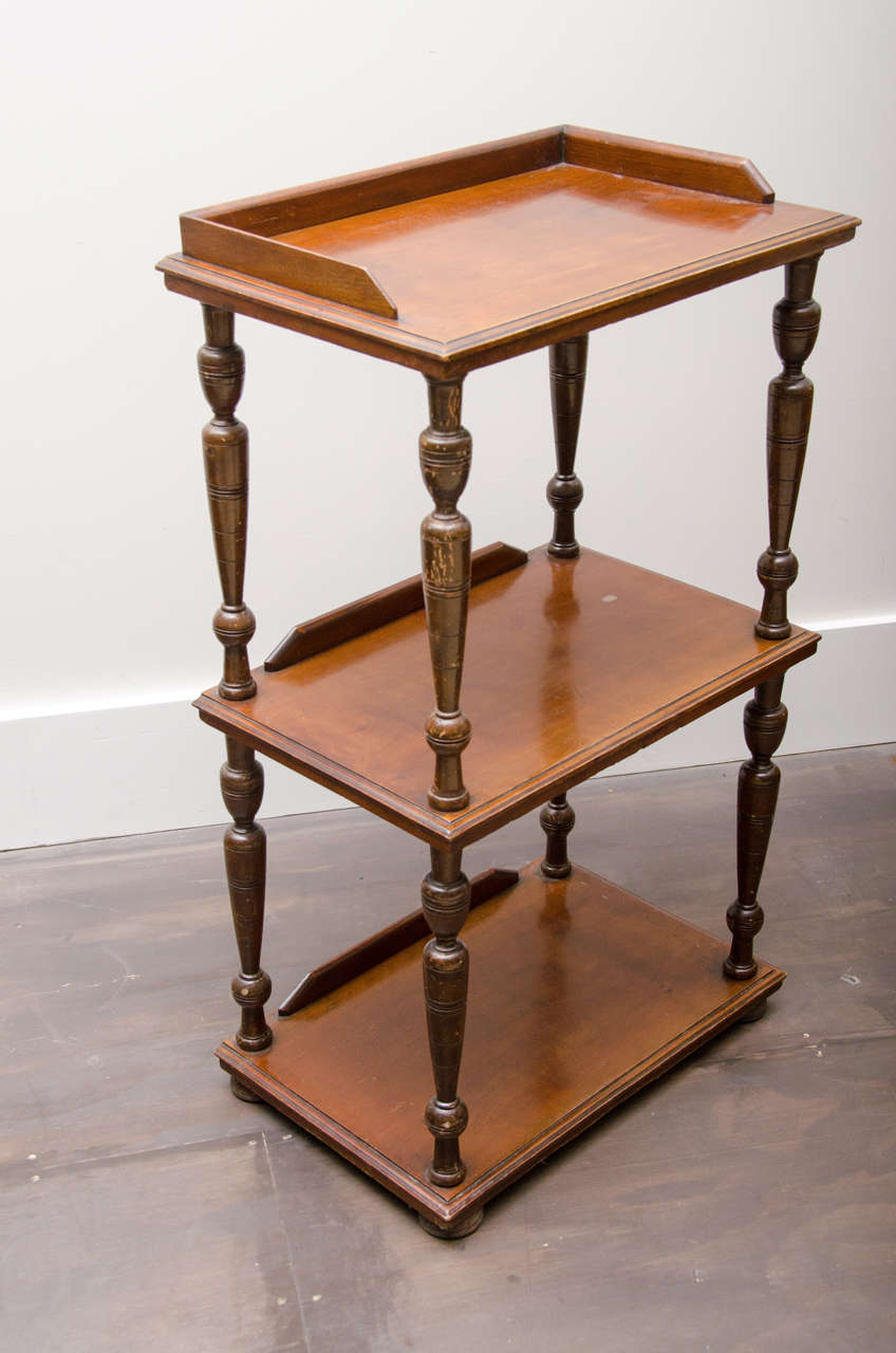 Superb three-tier mahogany étagère, England, 19th century. 

Exquisite mahogany wood, turned legs, handsome gallery top, and three tiers with ample space for storage and display. 

  