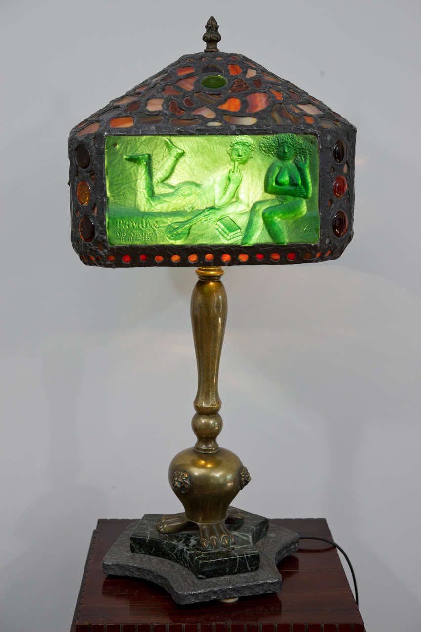 Unique Hungarian Secessionist  bronze table lamp with four green pate de verre 
panels depicting erotic scenes from Ovid and capped with mosaic colored glass. 
Monogramed at each panel.