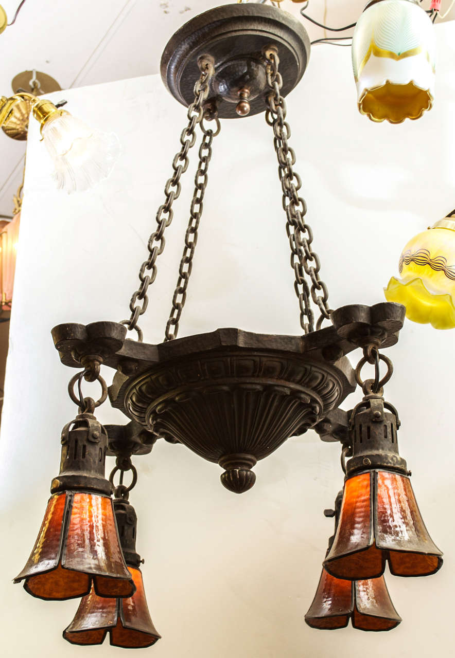 This beautiful hammered iron period arts and crafts chandelier has a nice warm, dark, original patina and four original bent glass shades.  A high quality, well constructed piece of lighting.