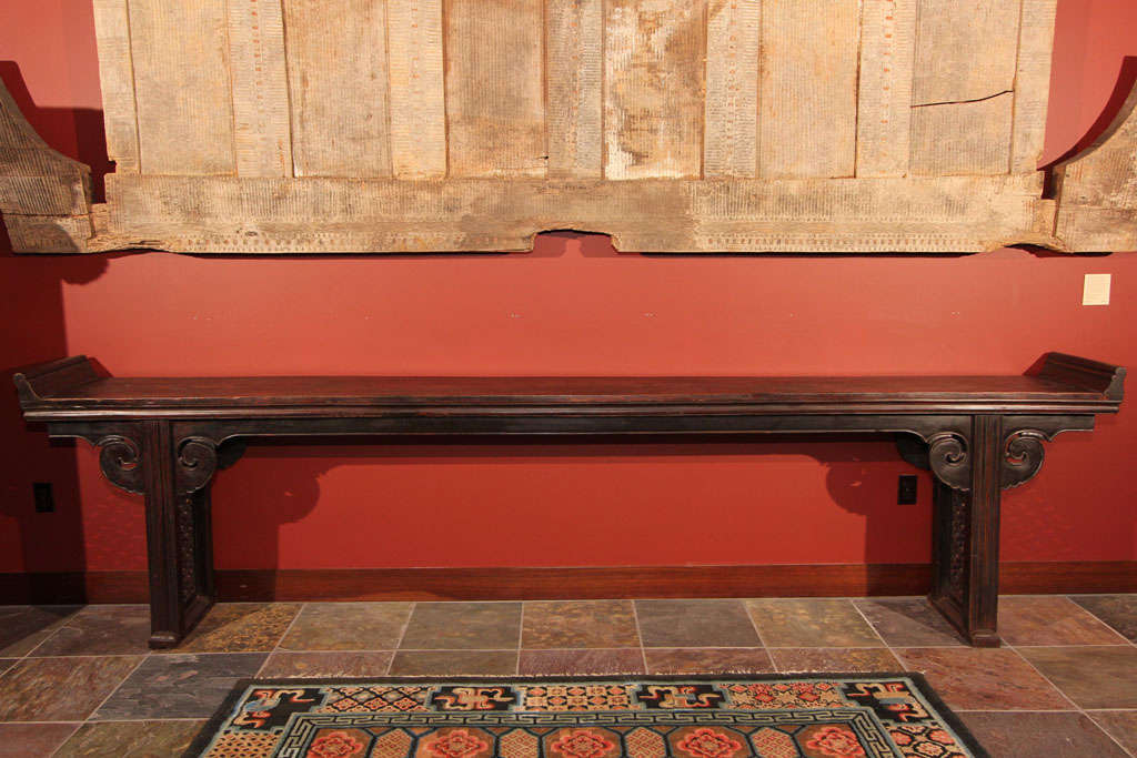 Exceptionally long Chinese altar table with original lacquered finish. Constructed of jumu (elm) wood, the table with solid slab top and everted end flanges (jiatousun qiaotouan). The solid skirt with beaded edge and ruyi (wish granting fungus)