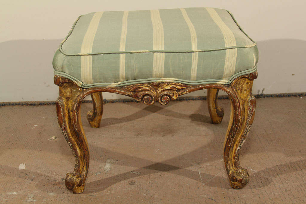 A mid 19th century Italian painted and gilded footstoll custom covered in silk.