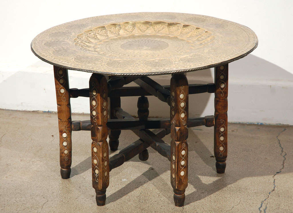 Moroccan Brass tray table finely hand graved with peacoks and chiseled designs, foliages and birds.Beautiful tray, the wooden stand is carved and inlaid with brass and mother of pearl. The tray is removable and could be used as a large platter and